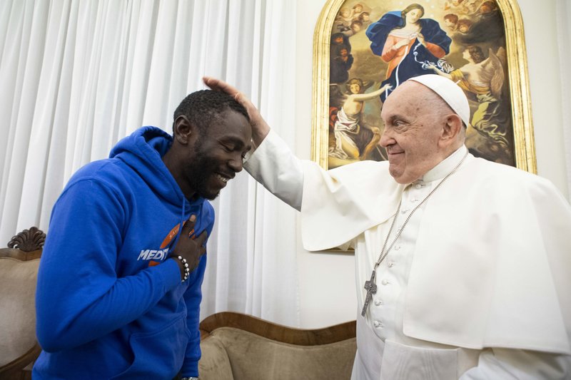 El Papa Francisco bendice a Mbengue Nyimbilo Crepin, un migrante de Camerún cuya esposa e hija murieron en julio cruzando el desierto del norte de África, durante una reunión en la Domus Sanctae Marthae en el Vaticano el 17 de noviembre de 2023. (CNS photo/Vatican Media)