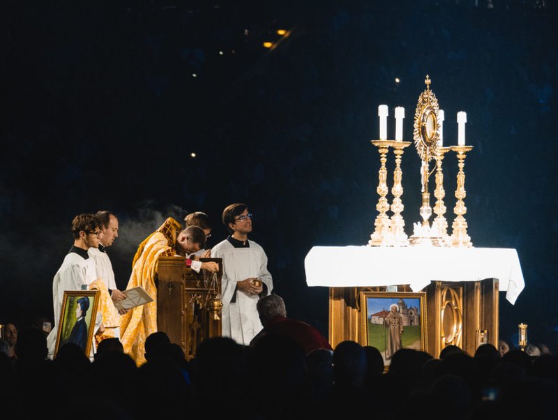 El Obispo Andrew H. Cozzens se arrodilla en oración ante la custodia durante la adoración eucarística en la sesión inaugural del Congreso Eucarístico Nacional en el Lucas Oil Stadium de Indianápolis el 17 de julio. El altar estaba adornado con los iconos de los santos que llevaban los peregrinos perpetuos de la peregrinación nacional de dos meses. (OSV News/Bob Roller)