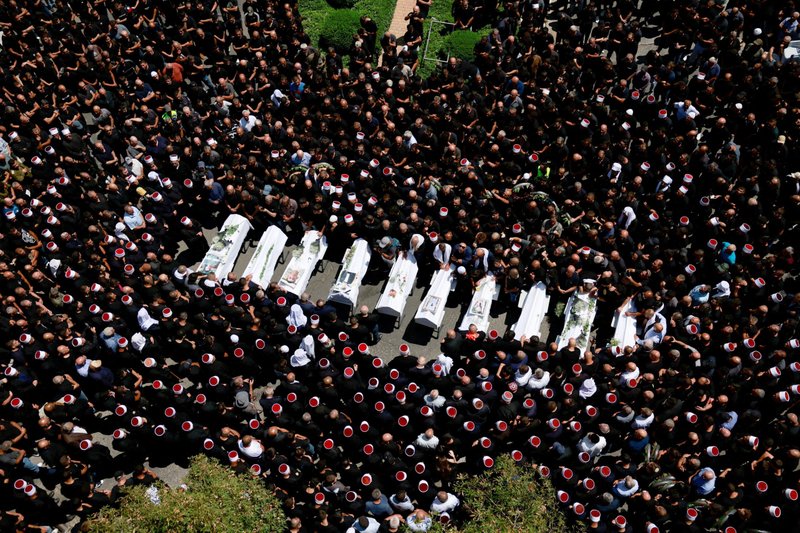 Un grupo de personas se reúne el 28 de julio de 2024 durante el funeral de los niños que murieron en un campo de fútbol por un ataque con misiles en Majdal Shams, un pueblo druso en los Altos del Golán ocupados por Israel. Según las autoridades israelíes, un cohete lanzado desde Líbano alcanzó el campo de fútbol y mató a 12 niños y adolescentes, en lo que el ejército calificó como el ataque más mortífero contra civiles desde el 7 de octubre de 2023. Oriente Próximo se prepara para un posible estallido de violencia tras el ataque. (Foto de OSV News/Ammar Awad, Reuters)