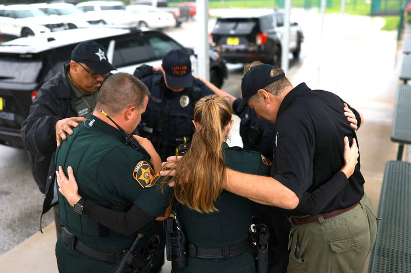 Members of the Polk County Sheriff's Office pray outside a shelter in Lakeland, Fla., Oct. 9, 2024, as Hurricane Milton approaches. As the powerful hurricane charged through the Gulf of Mexico toward Florida that day, officials said time was running out for people to evacuate -- and the odds of survival were bleak for holdouts determined to stay.(OSV News photo/Jose Luis Gonzalez, Reuters)