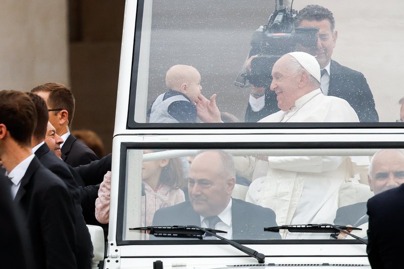 El Papa Francisco saluda a un niño mientras pasea en el papamóvil por la Plaza de San Pedro antes de su audiencia general semanal en el Vaticano el 23 de octubre de 2024. (CNS photo/Lola Gomez)