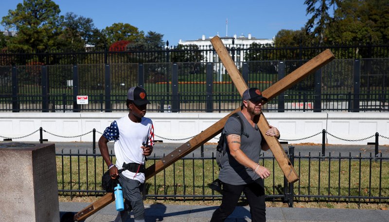 Un hombre lleva una gran cruz de madera cerca de la Casa Blanca en Washington D.C. el 5 de noviembre de 2024, día de las elecciones. (Foto OSV News/Daniel Cole, Reuters)