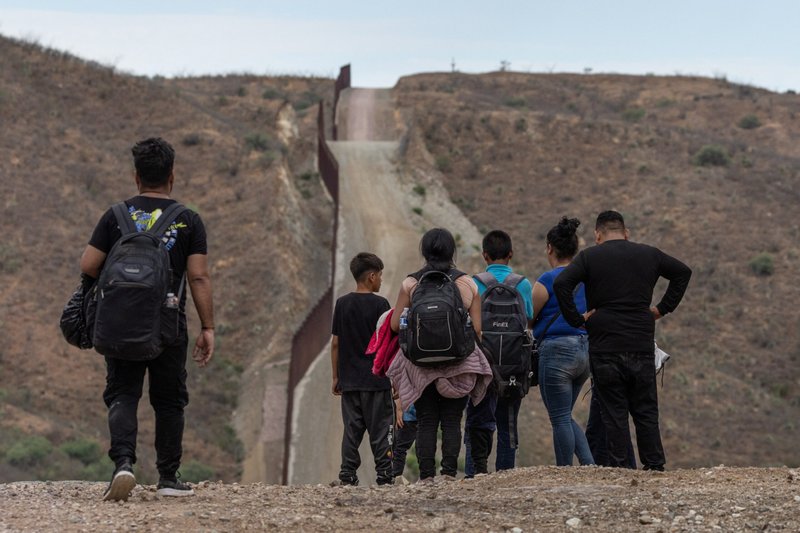El Muro Fronterizo se ve en el fondo mientras los migrantes de América del Sur y Central buscan entregarse a los funcionarios de inmigración después de cruzar a los Estados Unidos desde México en Ruby, Arizona, 24 de junio de 2024. (Foto de OSV News/Adrees Latif, Reuters)