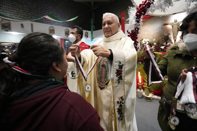El padre jesuita Hernán Paredes entrega una medalla conmemorativa a una participante de la Carrera Antorcha Guadalupana tras su llegada a la iglesia de Nuestra Señora del Carmen en Staten Island, N.Y., el 11 de diciembre de 2022, víspera de la festividad de Nuestra Señora de Guadalupe. El recorrido anual de la antorcha en honor a la patrona de México y las Américas comienza en la Basílica de Nuestra Señora de Guadalupe en la Ciudad de México y concluye en la Catedral de San Patricio en la ciudad de Nueva York en la fiesta de Nuestra Señora de Guadalupe el 12 de diciembre. (Foto OSV News/Gregory A. Shemitz)