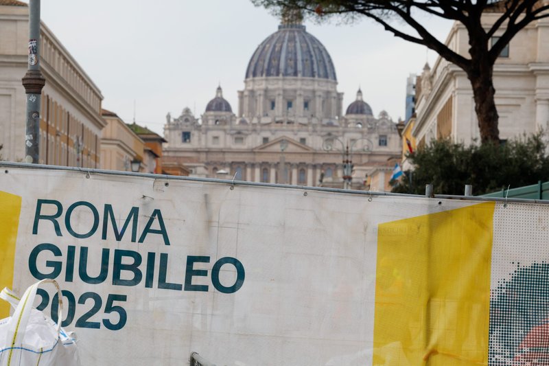 La cúpula de la Basílica de San Pedro se ve sobre una barricada de tela en la que se lee “Roma Jubileo 2025” que rodea una obra al comienzo del amplio bulevar que conduce a la Plaza de San Pedro el 4 de diciembre de 2024. La ciudad de Roma se prepara para el Año Santo con cientos de obras y proyectos de restauración. (Foto CNS/Lola Gomez)