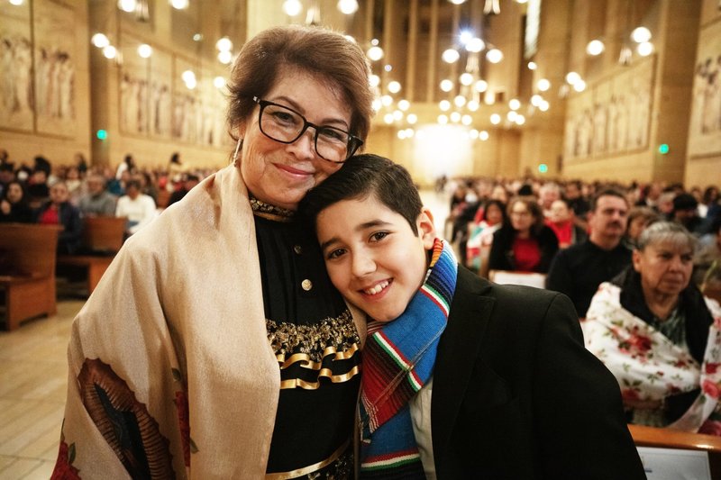 Rosa González, a la izquierda, sonríe con su nieto Sebastián, de 12 años, después de que éste cumplió con la tradición familiar de rezar el rosario en la vigilia de Las Mañanitas para celebrar a Nuestra Señora de Guadalupe. (Víctor Alemán)