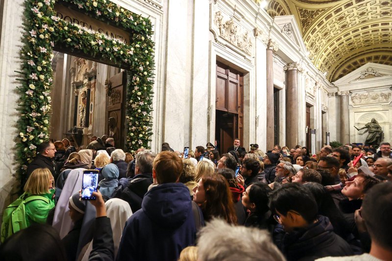 Visitantes atraviesan la Puerta Santa de la Basílica de Santa María la Mayor, en Roma, el 1 de enero de 2025, tras su inauguración ceremonial por el cardenal Rolandas Makrickas, arcipreste coadjutor de la basílica. (Foto CNS/Lola Gomez)