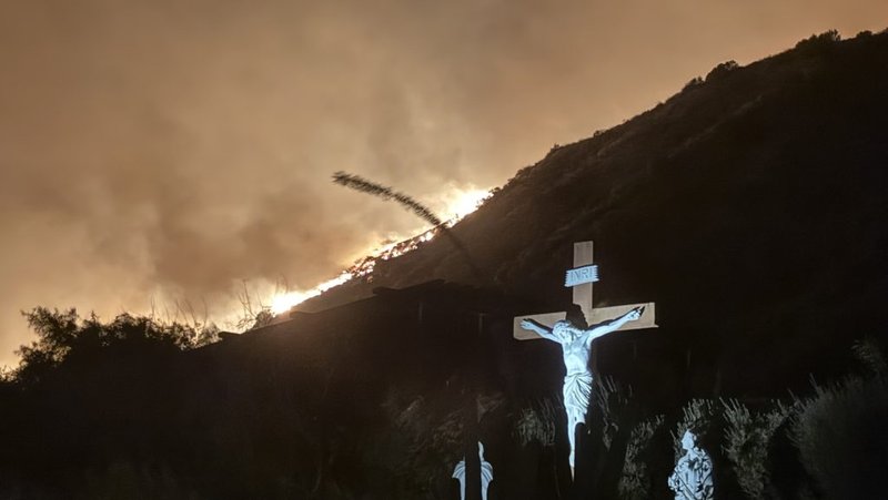 Una cruz de Jesús en el Centro de Retiros Pasionista Mater Dolorosa se muestra cerca de las llamas del incendio Eaton que ha asolado zonas como Sierra Madre, Altadena y Pasadena. (Página de Facebook de Mater Dolorosa)