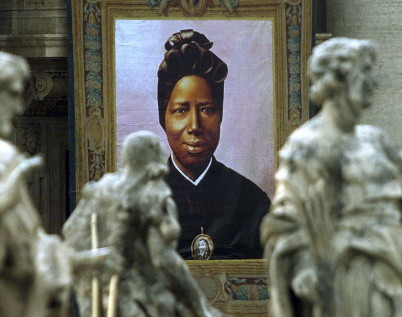 A file photo shows an image of St. Josephine Bakhita, a former Sudanese slave who became a nun, hangs from the facade of St. Peter's Basilica. January is Human Trafficking Awareness month in the U.S., the church celebrates International Day of Prayer and Awareness Against Human Trafficking Feb. 8, the feast day of St. Bakhita, who was kidnapped as a child and sold into slavery in Sudan and Italy. (OSV News photo/Paolo Cocco, Reuters) A file photo shows an image of St. Josephine Bakhita, a former Sudanese slave who became a nun, hangs from the facade of St. Peter's Basilica. January is Human Trafficking Awareness month in the U.S., the church celebrates International Day of Prayer and Awareness Against Human Trafficking Feb. 8, the feast day of St. Bakhita, who was kidnapped as a child and sold into slavery in Sudan and Italy. (OSV News photo/Paolo Cocco, Reuters)