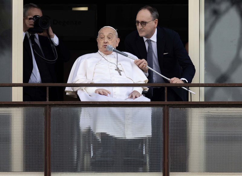 Massimiliano Strappetti, el enfermero que es el principal cuidador médico del Papa Francisco en el Vaticano, ajusta un micrófono para el Papa mientras saluda a una multitud de simpatizantes en el hospital Gemelli de Roma antes de regresar al Vaticano el 23 de marzo de 2025. (CNS photo/Pablo Esparza)