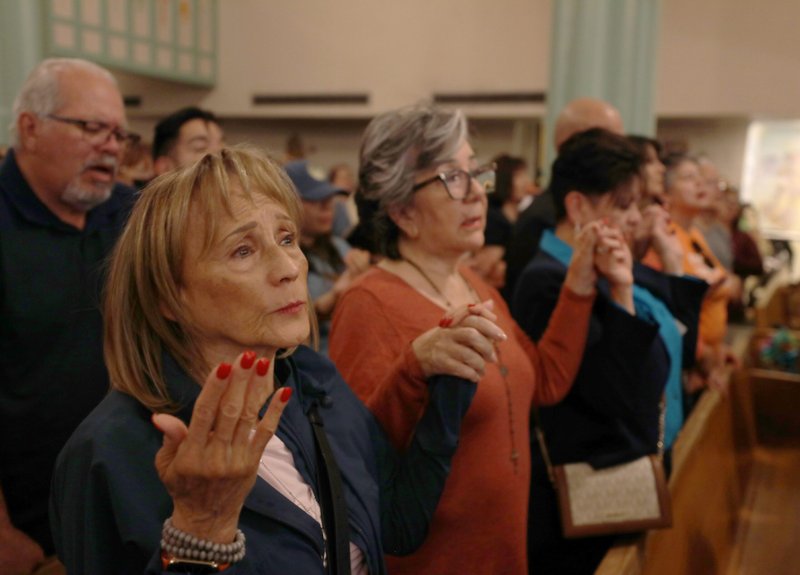 Un grupo de personas se dan la mano mientras el obispo de El Paso, Texas, Mark J. Seitz, dirige una vigilia de oración en la iglesia del Sagrado Corazón de El Paso el 24 de marzo de 2025, tras una concentración y una marcha de protesta contra las deportaciones masivas llevadas a cabo por el gobierno de EE.UU. (Foto OSV News/Bob Roller)