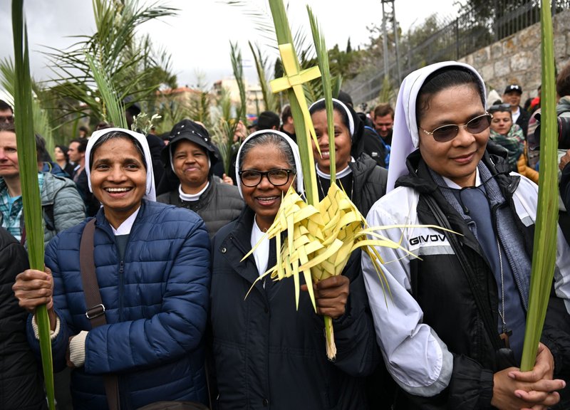 Los cristianos agitan ramas de palma y de olivo mientras recorren el camino tradicional que Jesús siguió en su última entrada en Jerusalén durante la procesión del Domingo de Ramos en el Monte de los Olivos el 13 de abril de 2025. (Foto OSV News/Debbie Hill)