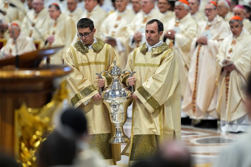 Diáconos llevan los óleos sacramentales después de ser bendecidos durante la Misa Crismal en la Basílica de San Pedro en el Vaticano el 17 de abril de 2025. El cardenal Domenico Calcagno, presidente retirado de la Administración del Patrimonio de la Santa Sede, presidió la liturgia como delegado del Papa Francisco. (Foto CNS/Lola Gomez)