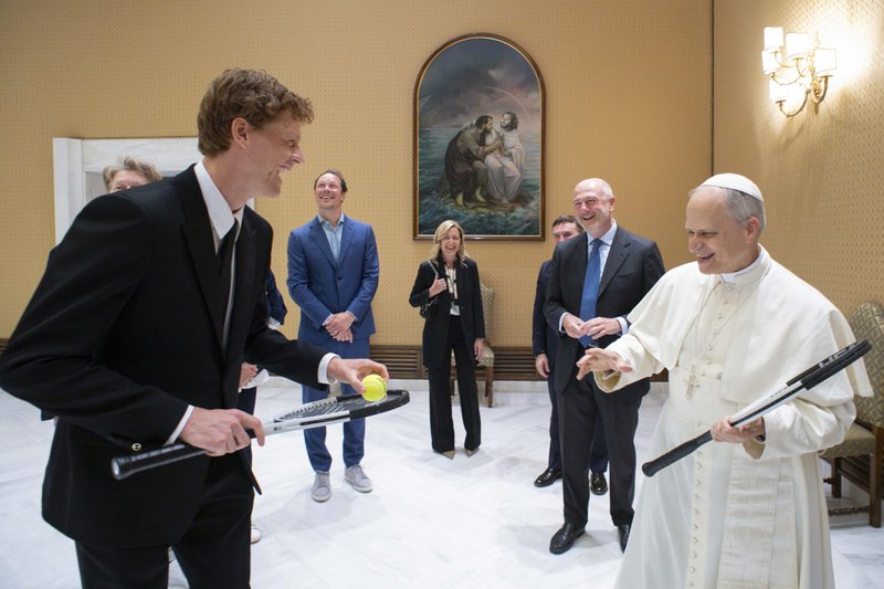 Jannik Sinner, el tenista número 1 del mundo, bromea con el Papa León XIV, tras regalarle una raqueta de tenis el 14 de mayo de 2025, durante una reunión en el Vaticano. El Papa dijo que no creía que debieran intentar jugar en la sala de reuniones porque podrían romper algo. (CNS photo/Vatican Media)