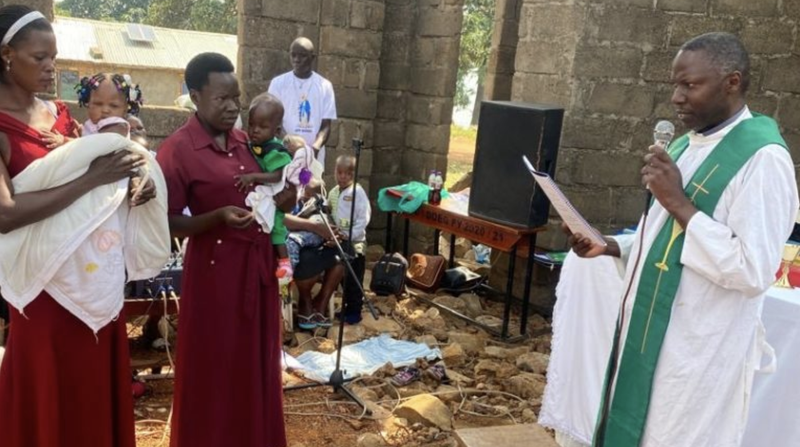 El padre John Kyebasuuta celebra misa en la isla de Namiti, en Uganda, en una iglesia primitiva que ayudó a los pobladores locales a reconstruir. (Padre John Kyebasuuta)