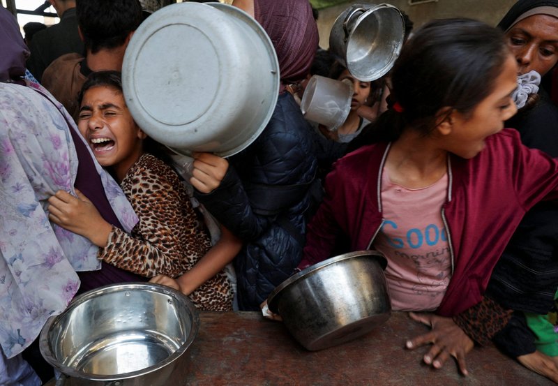 Una niña palestina desplazada por la ofensiva militar israelí reacciona mientras espera con otros jóvenes el 21 de mayo de 2025 para recibir alimentos cocinados por una cocina de caridad en la ciudad de Gaza, Franja de Gaza. (Foto de OSV News/Mahmoud Issa, Reuters)