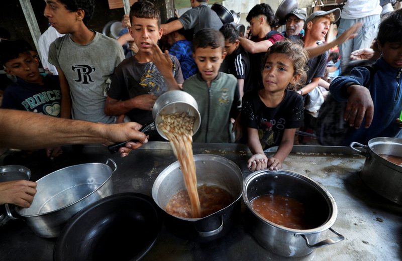 Jóvenes palestinos desplazados por la ofensiva militar israelí reaccionan el 21 de mayo de 2025, mientras esperan recibir alimentos cocinados por una cocina benéfica en la ciudad de Gaza, Franja de Gaza. (Foto de OSV News/Mahmoud Issa, Reuters)