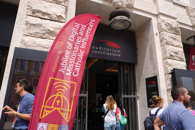 Un peregrino lleva una cruz mientras los participantes en el Jubileo de Misioneros Digitales e Influyentes Católicos atraviesan la Puerta Santa de la Basílica de San Pedro en el Vaticano el 29 de julio de 2025. (CNS photo/Lola Gomez)