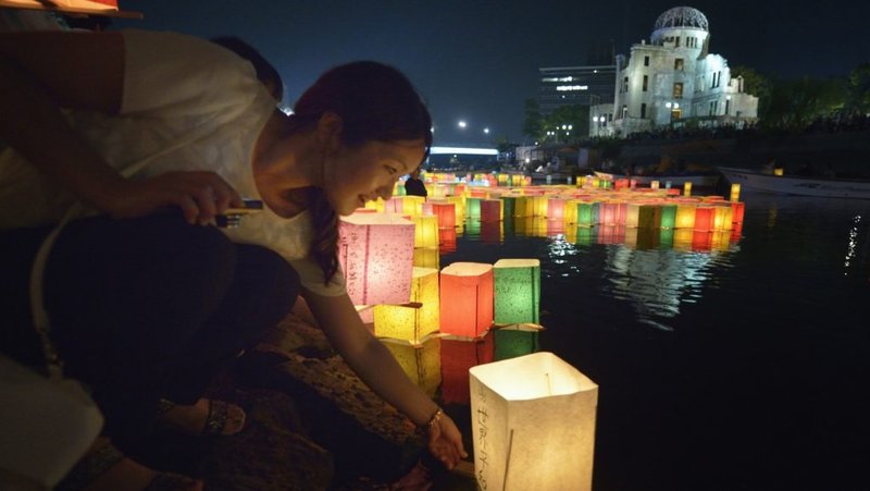Una mujer coloca una linterna flotante en el río el 6 de agosto de 2015, en Hiroshima, Japón, en conmemoración del 70 aniversario del bombardeo atómico de la ciudad. Los obispos católicos de Japón piden la prohibición de las armas nucleares mientras anuncian un programa de oración de 10 días para conmemorar el aniversario de los bombardeos de Hiroshima y Nagasaki. (CNS photo/Paul Jeffrey)