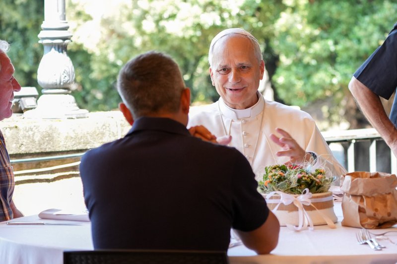 El Papa León XIV habla con un invitado que es parte de un grupo de personas asistidas por la agencia Cáritas diocesana de Albano durante un almuerzo en el Borgo Laudato Si' en Castel Gandolfo, Italia, 17 de agosto de 2025. El encuentro tuvo lugar tras una Misa que el Papa celebró ese mismo día en Albano Laziale. (Foto CNS/Lola Gomez)