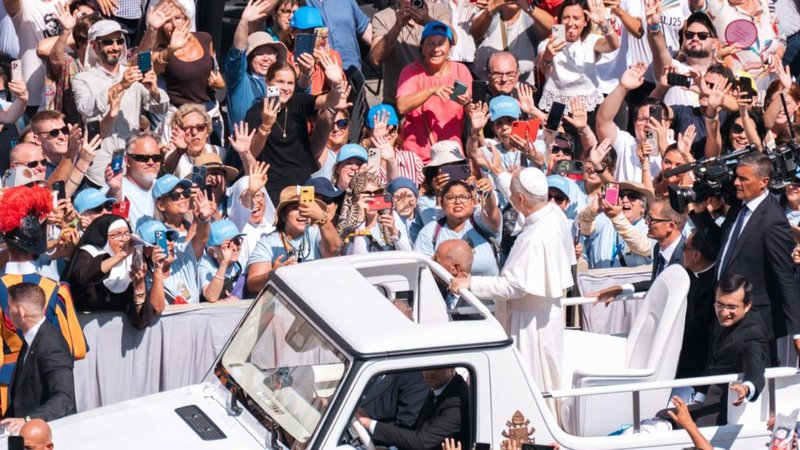 Evelyn Moreira (al centro, sosteniendo el rosario) y otros peregrinos de Los Ángeles con camisetas azules saludan al Papa León XIV después de la Misa de canonización de los santos Pier Giorgio Frassati y Carlo Acutis el 7 de septiembre en la Plaza de San Pedro. (Isabel Cacho/Arquidiócesis de LA)