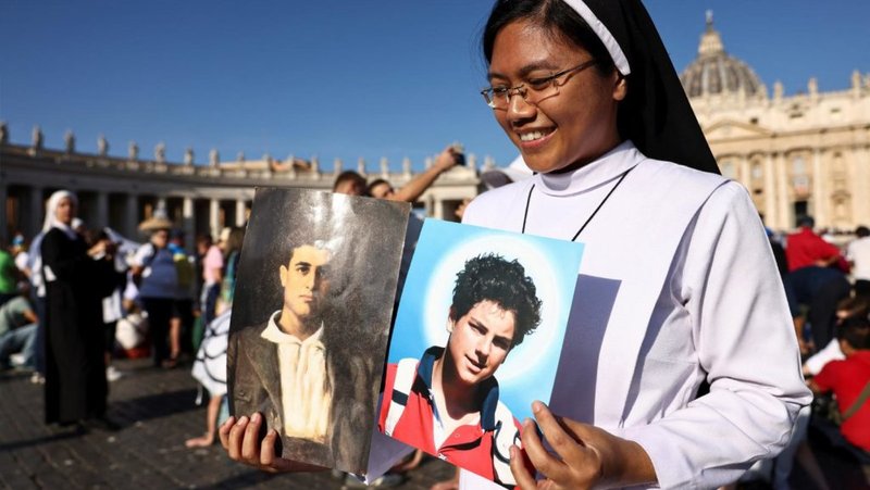 Una monja sostiene una foto de Carlo Acutis y Pier Giorgio Frassati en la Plaza de San Pedro del Vaticano, el 7 de septiembre de 2025. (OSV News/Matteo Minnella, Reuters)