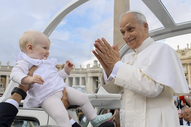 El papa León XIV saluda a un niño mientras recorre la plaza de San Pedro en el Vaticano en el papamóvil antes de su audiencia general semanal el 24 de septiembre de 2025. (Foto CNS/Vatican Media)
