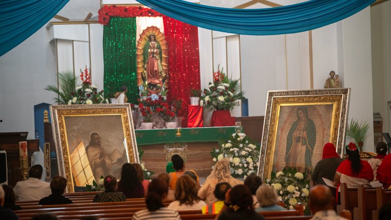 Feligreses de la Iglesia de Nuestra Señora de Lourdes en East LA rezan ante las imágenes peregrinas de la Virgen de Guadalupe y San Juan Diego. (John Rueda)