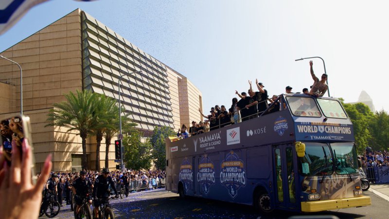 Los jugadores de los Dodgers y sus familias saludan a la multitud mientras el desfile de la victoria del 3 de noviembre por el campeonato de la Serie Mundial pasa frente a la Catedral de Nuestra Señora de los Ángeles. (Reese Cuevas)