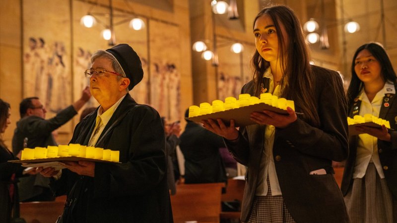 Los fieles llevan velas a pilas a la Catedral de Nuestra Señora de los Ángeles el 21 de diciembre. Las velas llevaban los nombres de personas sin hogar de la zona que fallecieron durante el último año. Ochenta y cuatro de las 1564 velas no tenían nombre, lo que indica el número de fallecidos que no fueron identificados. (John Rueda)