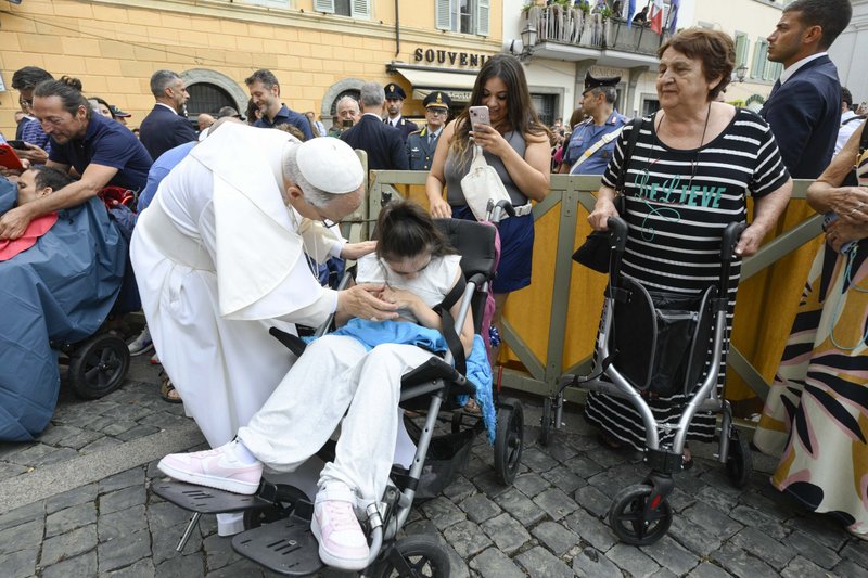 El papa León XIV saluda a una joven en silla de ruedas tras dirigir el rezo del Ángelus frente al palacio papal de Castel Gandolfo, Italia, el 17 de agosto de 2025. (Foto CNS/Vatican Media)