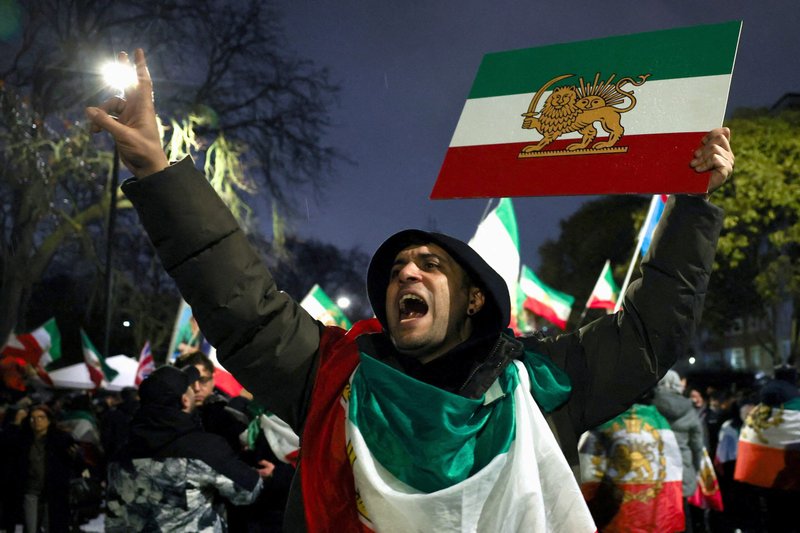 Un hombre gesticula mientras muestra la bandera nacional "León y Sol" anterior a la Revolución Iraní, mientras los manifestantes se reúnen frente a la embajada iraní en Londres el 11 de enero de 2026, durante una concentración en apoyo a las protestas nacionales en Irán. (Foto de OSV News/Isabel Infantes, Reuters)