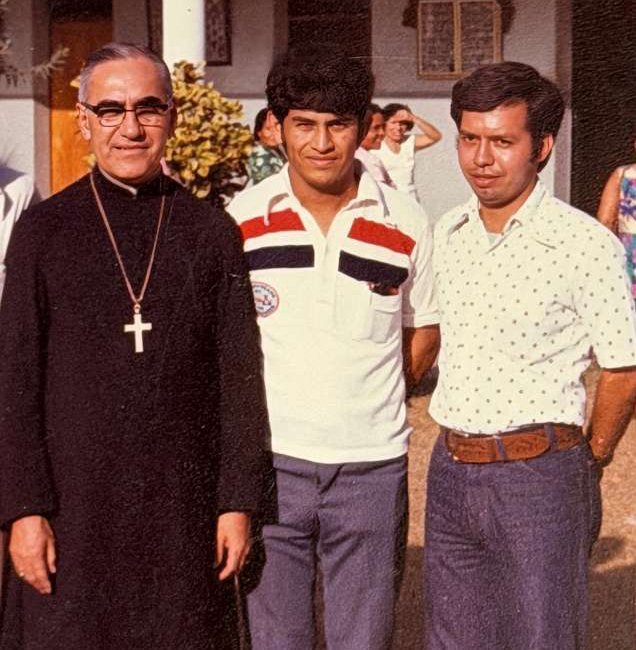 En una fotografía sin fecha, San Óscar Romero aparece junto a los seminaristas Octavio Durán y Joaquín Álvarez Campos durante una visita a la parroquia María Auxiliadora en San Salvador, El Salvador. Tras el martirio de Romero, Durán se convirtió en fraile franciscano y Álvarez fue ordenado sacerdote diocesano. El 14 de enero de 2026, durante una peregrinación con los Padres y Hermanos Maryknoll en El Salvador, el hermano Durán tuvo el privilegio de entregar los zapatos de San Romero a la hermana Tránsito de la Cruz, superiora de la comunidad del Hospital Divina Providencia. (Foto de OSV News/cortesía de Octavio Durán, Maryknoll Magazine)