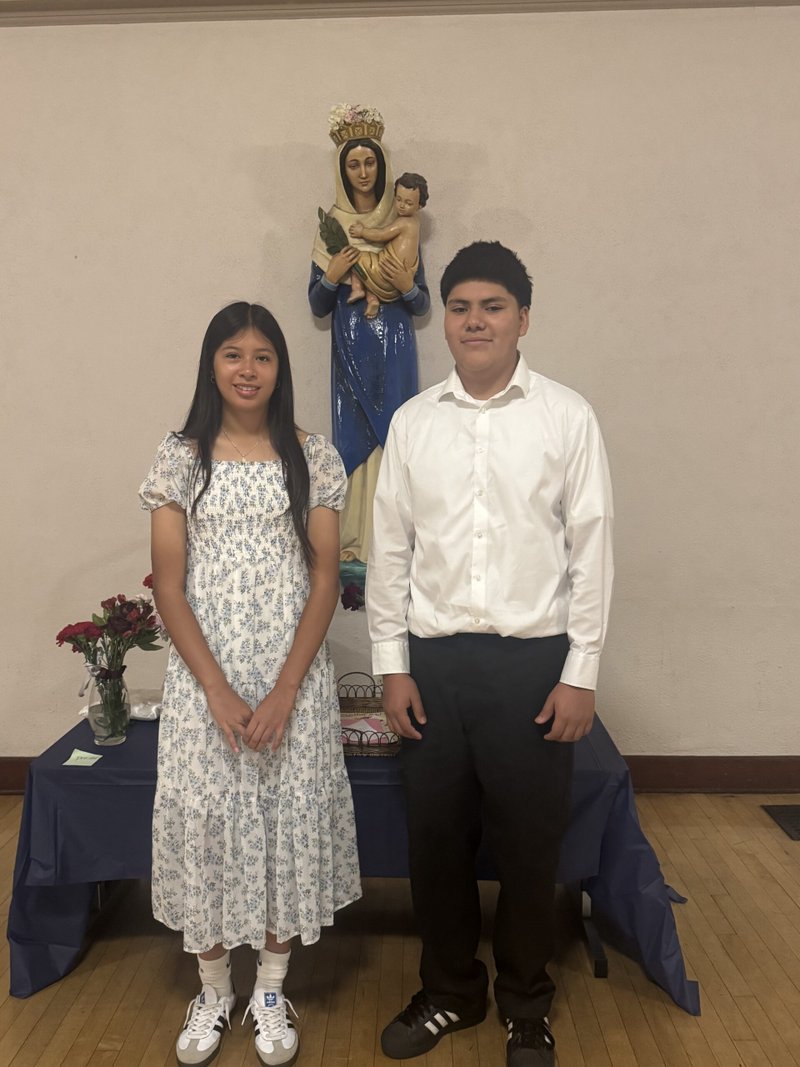 Eighth-graders Sophia Diaz and Emmanuel Mendoza at Notre Dame School in Santa Barbara pose with the crowned Virgin Mary statue during a May crowning event. (Notre Dame School)