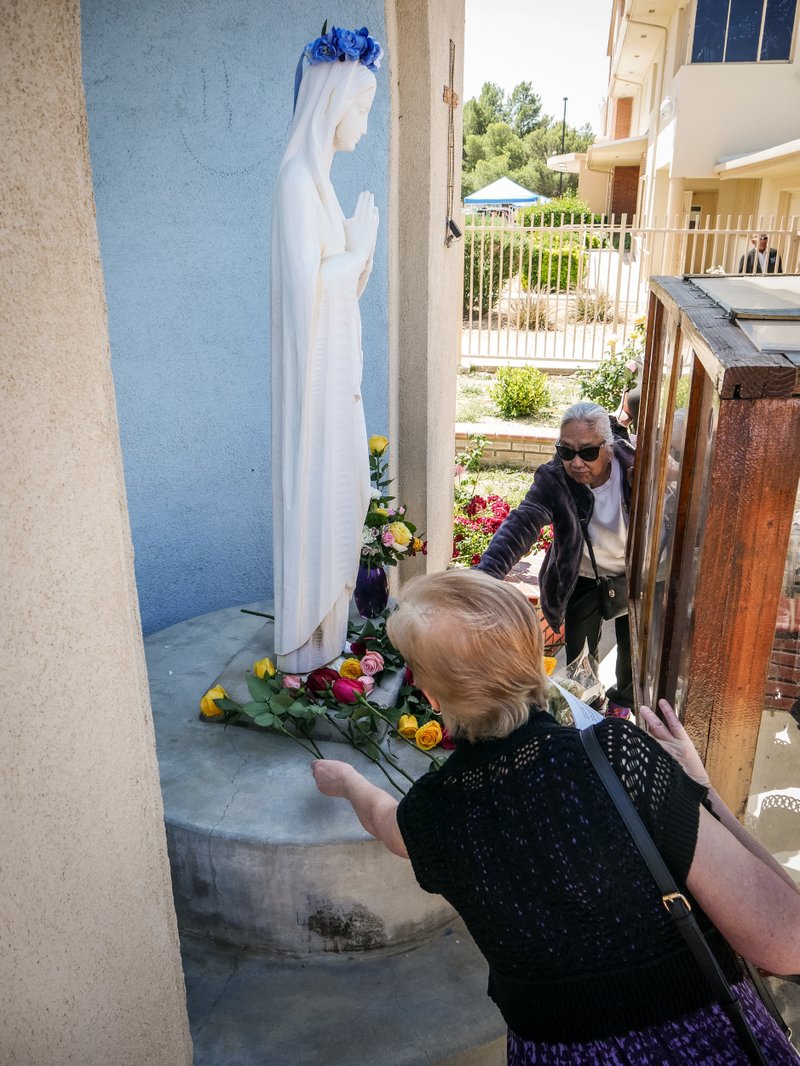 Parishioners at Sacred Heart Church in Lancaster lay flowers at the feet of the Virgin Mary in a May crowning event. (Katie Trejo)