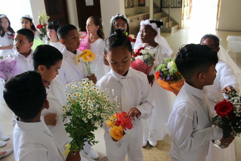 Students at St. John Chrysostom School in Inglewood prepare to lay their flowers at the feet of their Virgin Mary statue during a May crowning event. (St. John Chrysostom School)