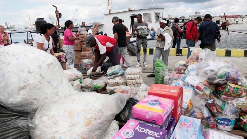 Integrantes de una flotilla que partió de México, junto con trabajadores portuarios locales, descargan ayuda humanitaria a su llegada a la bahía de La Habana el 24 de marzo de 2026. Catholic Relief Services (CRS), la agencia humanitaria y de desarrollo de los obispos católicos de Estados Unidos, recibió 60 millones de dólares del Departamento de Estado de EE.UU. para ampliar la asistencia humanitaria a familias vulnerables en toda Cuba. (Foto de OSV News/Jorge Luis Bañós, pool vía Reuters)