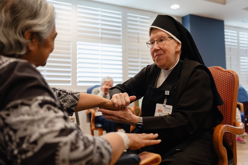 Una hermana carmelita atiende a una residente en Ozanam Hall, ubicado en el vecindario de Bayside, en el distrito de Queens, Nueva York. El 30 de julio de 2026, un juez protegió temporalmente a cuatro órdenes religiosas femeninas y a ministerios católicos de salud de la aplicación de una ley del estado de Nueva York que permite a los médicos ayudar a adultos con enfermedades terminales a morir mediante el suicidio asistido. (Foto de OSV News/cortesía de Becket)