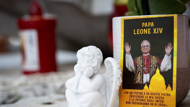 Una fotografía del papa León XIV junto a objetos devocionales, colocada sobre la estatua de san Juan Pablo II frente al Hospital Gemelli de Roma, donde el Pontífice se recupera de una cirugía en la que le extirparon el lóbulo inferior derecho del pulmón para tratar un tumor canceroso. (Foto de CNS/Cristian Gennari)