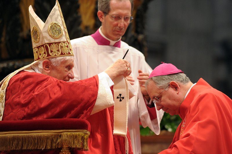 Pope Benedict XVI presents a pallium to Archbishop Jose H. Gomez of Los Angeles in St. Peter's Basilica at the Vatican June 29. During Mass the pope gave 41 archbishops the woolen pallium as a sign of their communion with him and their pastoral responsibility as shepherds. (CNS photo/L'Osservatore Romano)