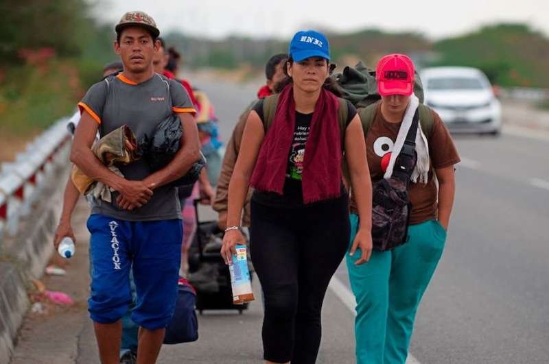 Venezuelan migrants walk southbound along the Pan American highway after receiving refugee permits at the Peruvian border. Credit: Cris Bouroncle / AFP / Getty Images.