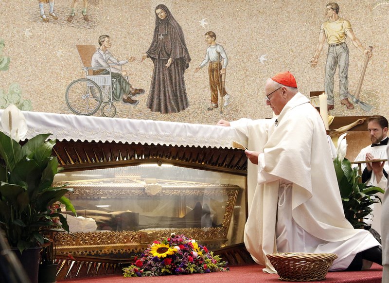 New York Cardinal Timothy M. Dolan prays at the tomb of St. Frances Xavier Cabrini during a Mass for immigrants July 13