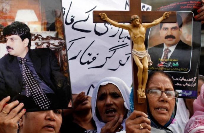 Christian women hold pictures of Shahbaz Bhatti