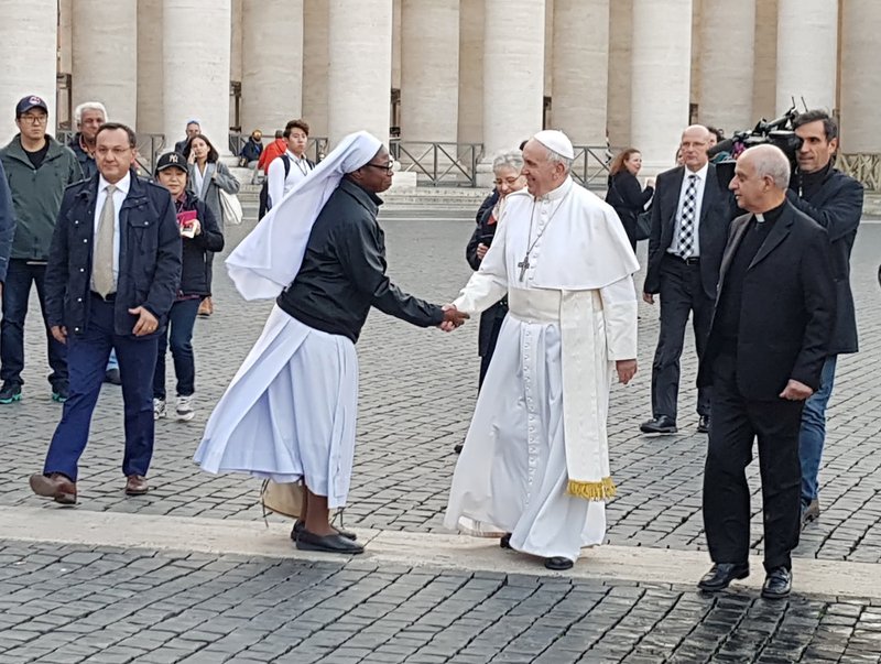 Pope Francis greets a woman religious in St. Peter's Square at the Vatican Nov. 16