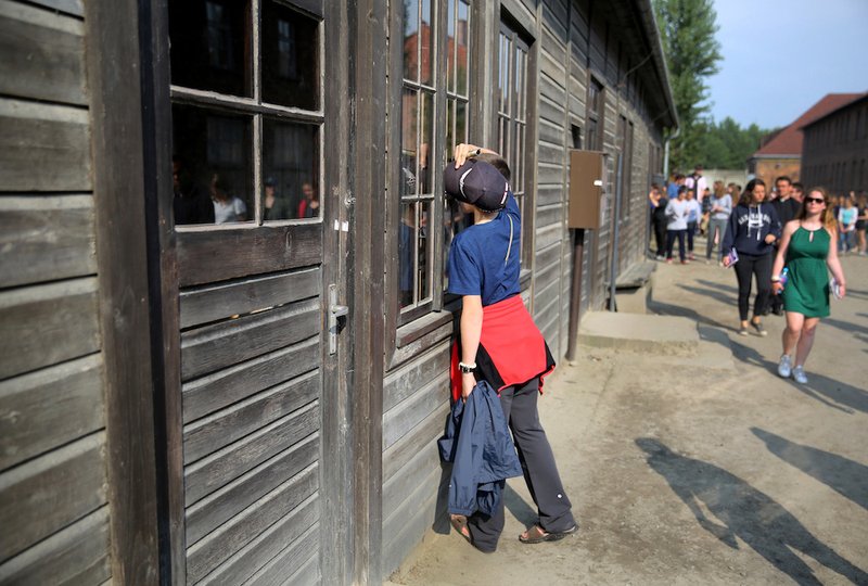 A young World Youth Day pilgrim looks inside a wooden prisoners' barrack during a July 25