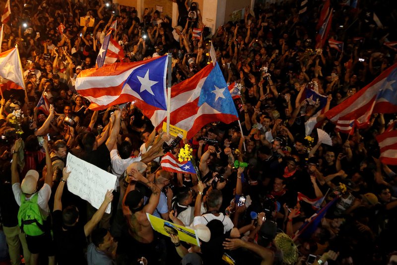 Demonstrators celebrate in the streets of San Juan after Puerto Rican Gov. Ricardo Rossello announced his resignation late July 24