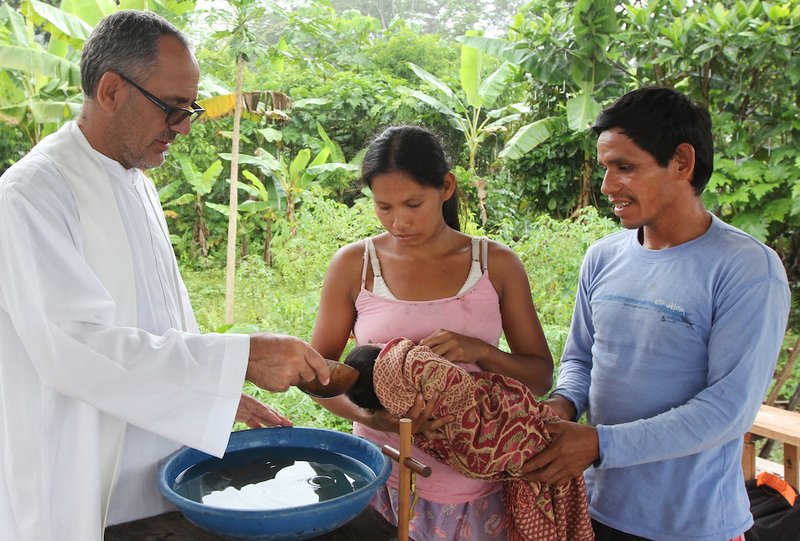 Spanish Augustinian Father Miguel Angel Cadenas baptizes an infant in an Urarina indigenous community on Peru's Urituyacu River June 6