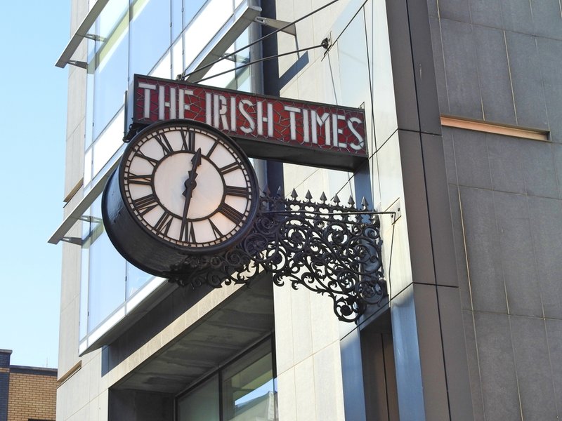 The Irish Times newspaper office building wall clock and name sign on Tara Street