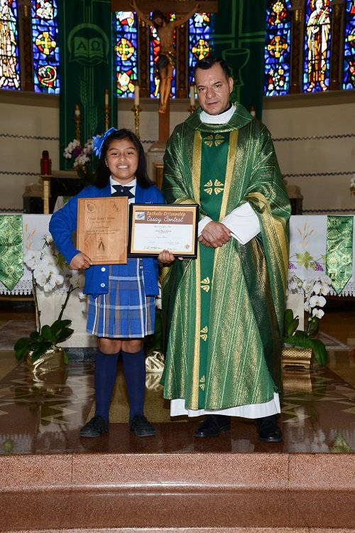 First place winner Alyson Flores with Father Rodolfo Prado. (Credit: Jose Romero)