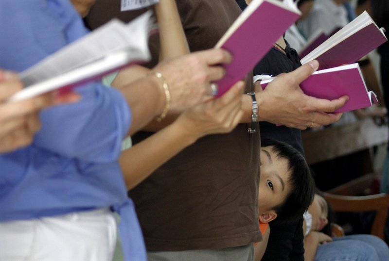 A boy attends Mass with his family at the Church of Sts. Peter and Paul in Singapore April 2